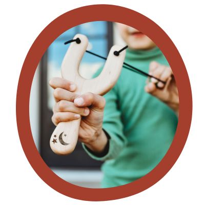 Outdoor Toys - Child playing with a toy boat with a leaf sail