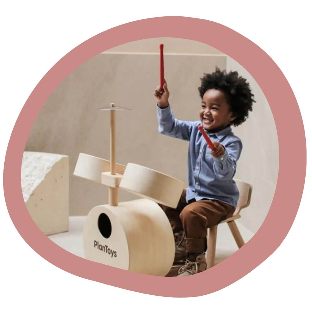 PlanToys - child playing wooden drums