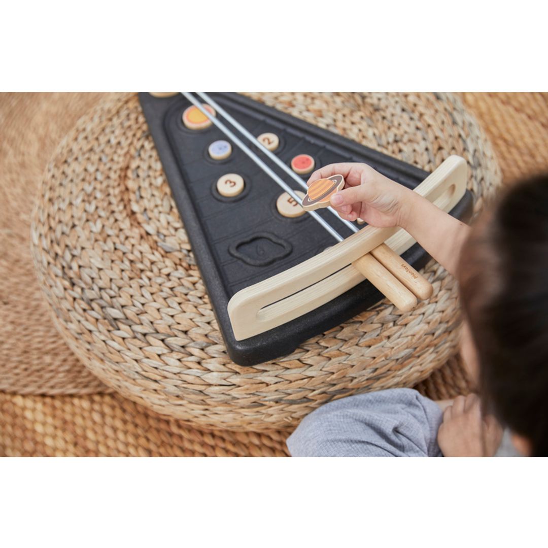 Girl holding planet in PlanToys - Land The Planet Game