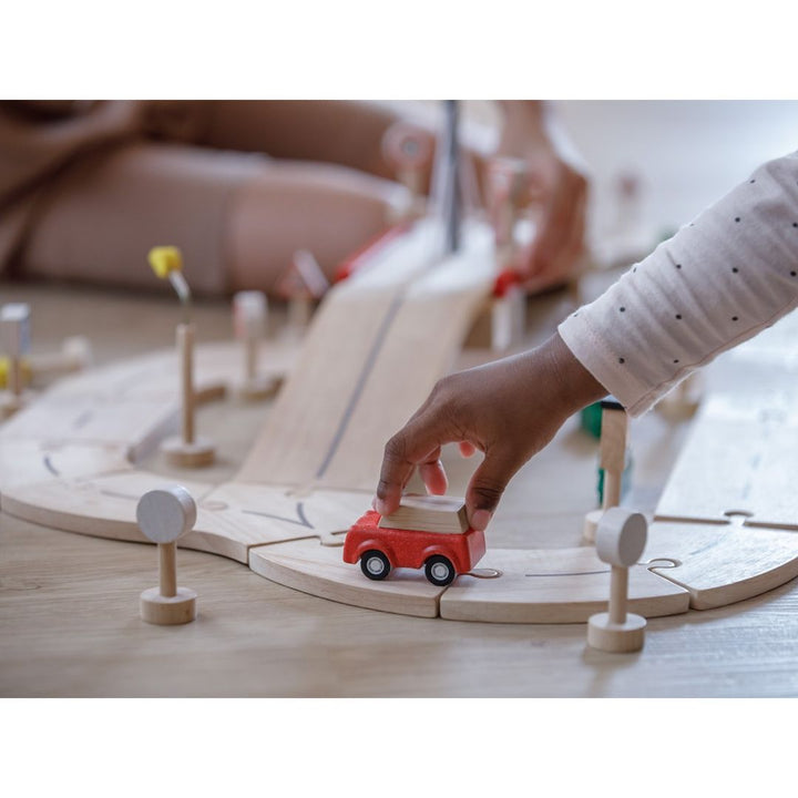 Child playing with car on PlanToys - Wooden Road System Play Set