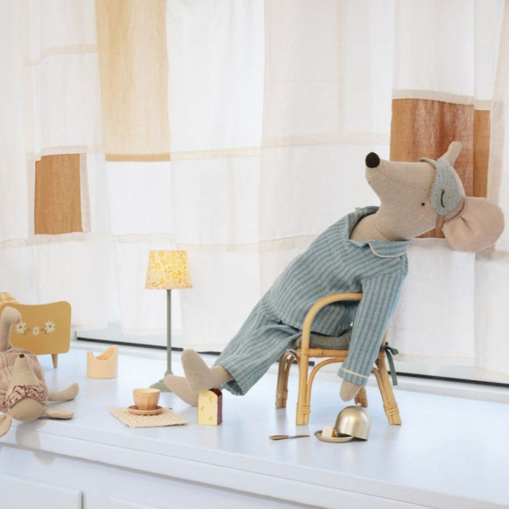 Maileg maxi mouse in blue striped pajamas sits in a toy chair with an eye mask on its head.