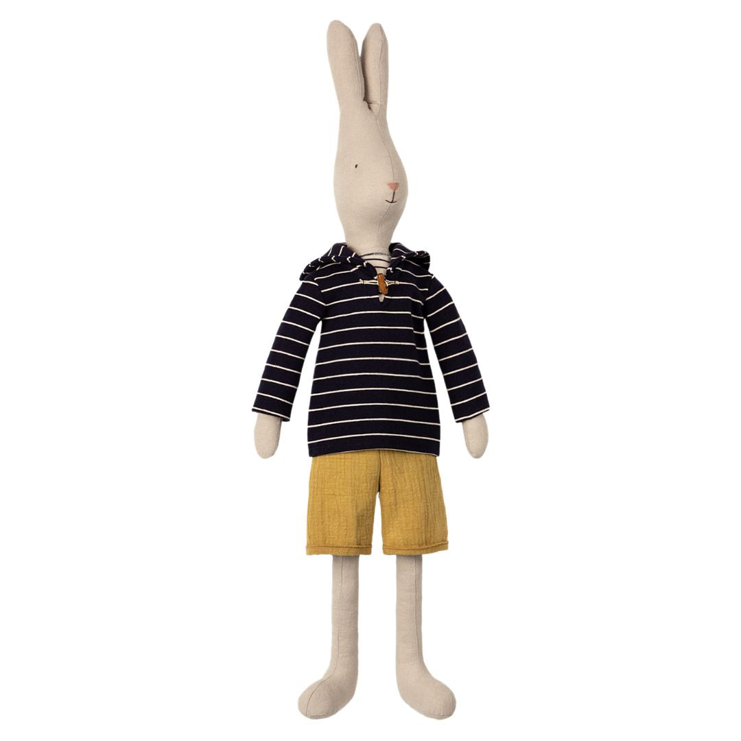 A white stuffed animal rabbit with a navy blue nautical striped shirt and yellow shorts by Maileg.