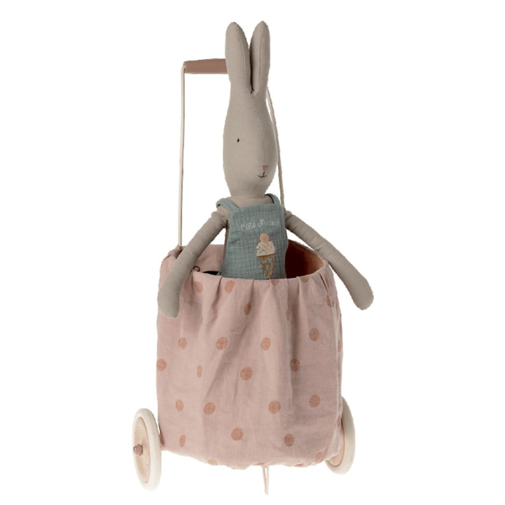 A bunny stuffed animal inside of a pink polkadotted Maileg trolley.