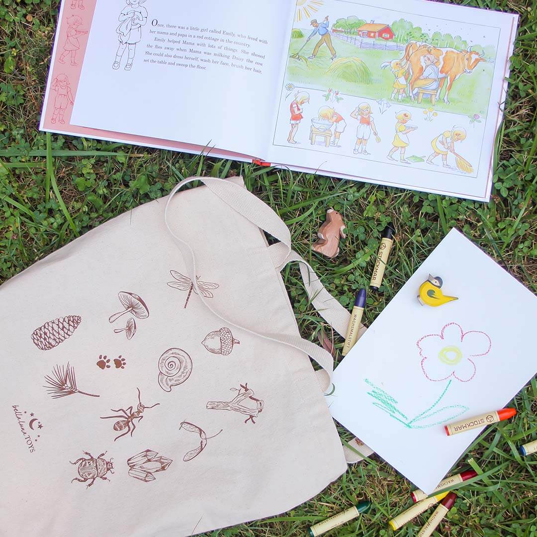 Nature Treasure Hunt Canvas Book Tote outdoors with book and toys.