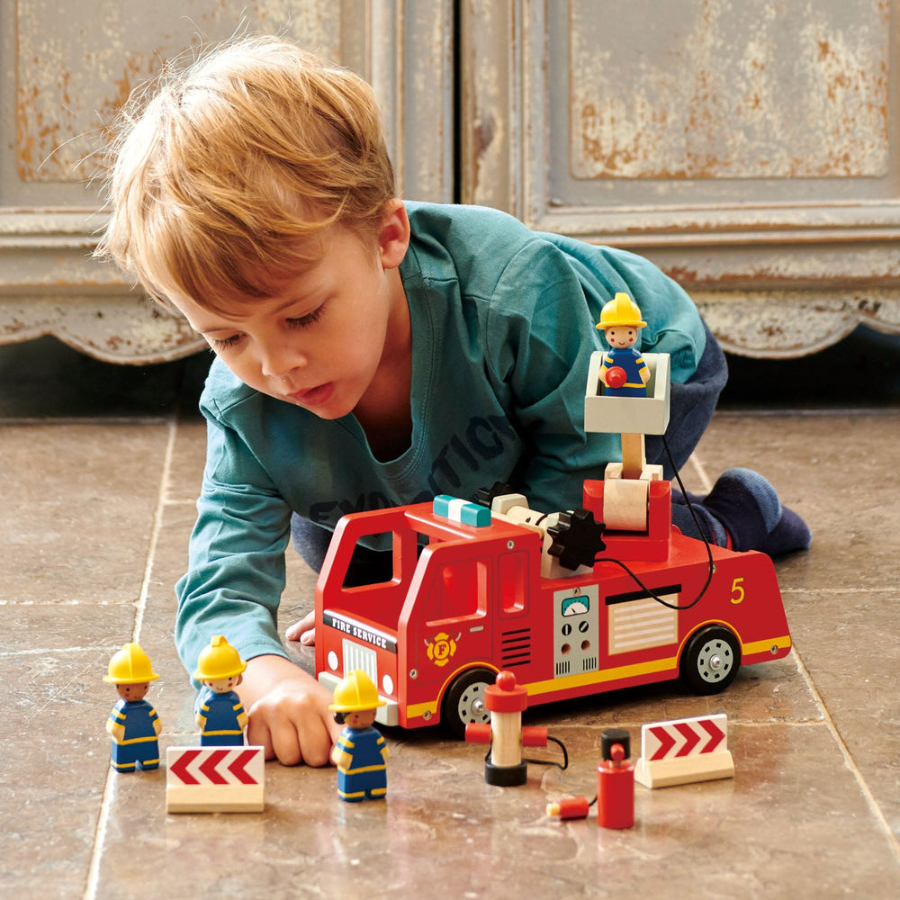 Kid playing with Tender Leaf Toys Wooden Fire Engine and Firefighter Play Set