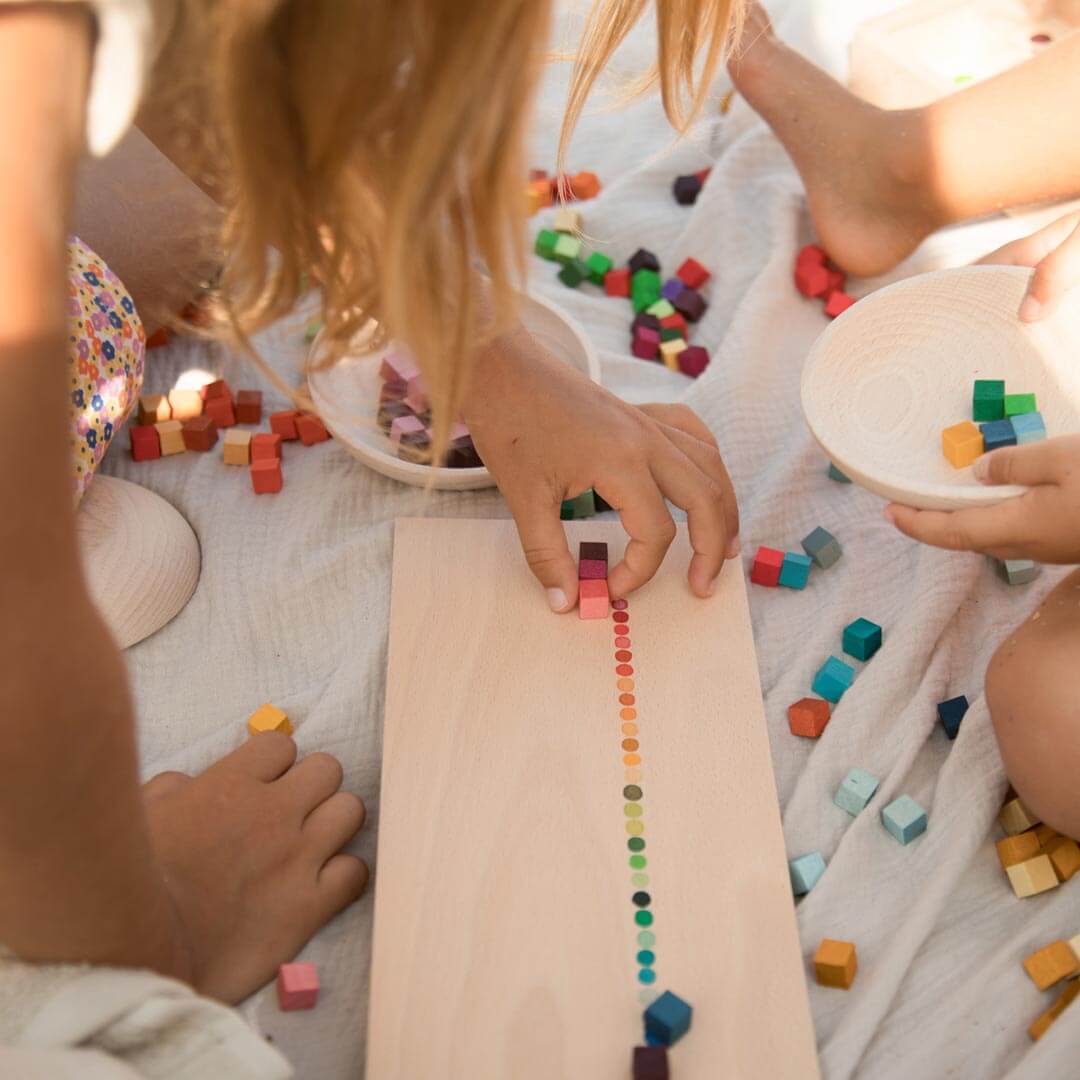 Child placing Grapat Mis & Match colorful wooden blocks with tray