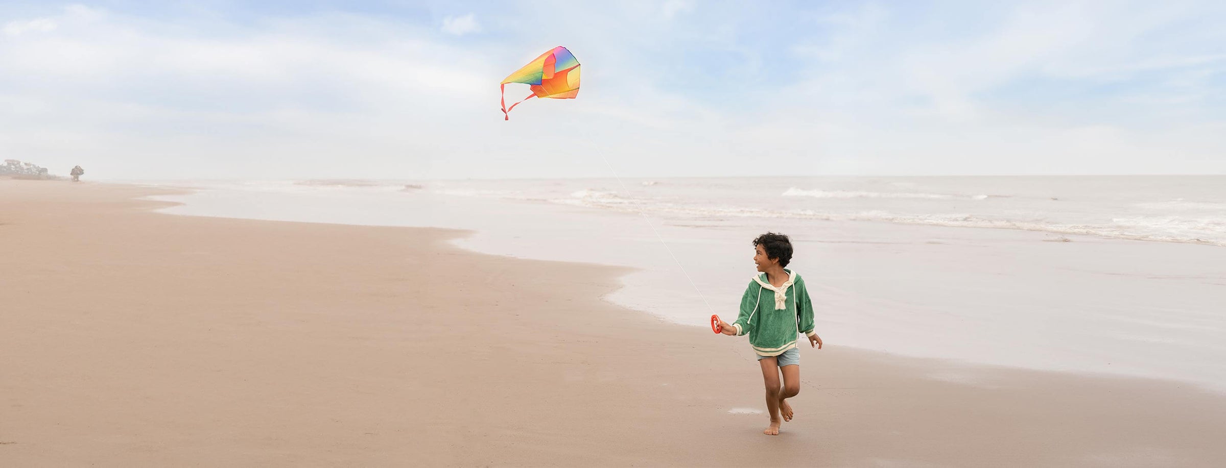 Child running on beach with Kid's Rainbow Kite