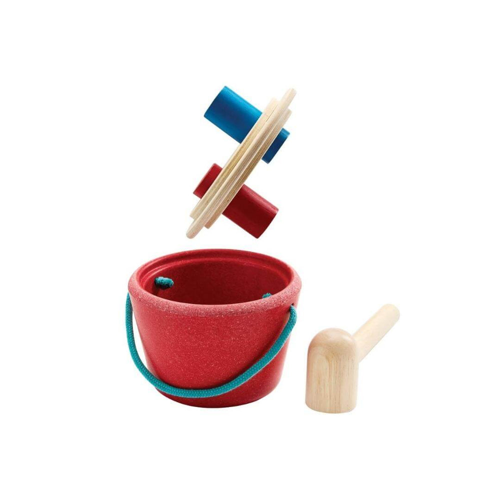 PlanToys Hammering Peg Bucket with wooden mallet and colorful red and blue pegs for Montessori-inspired play shown with the lid off and the hammer resting on a white surface.