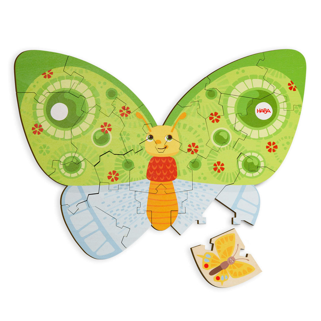 A colorful butterfly-shaped jigsaw puzzle with green, orange, and blue designs, mostly assembled with one piece missing.