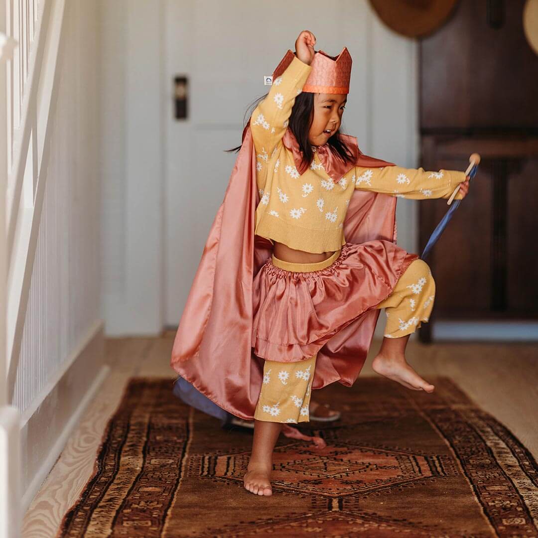 Girl marching with Sara's Silks Cape in Rosehip