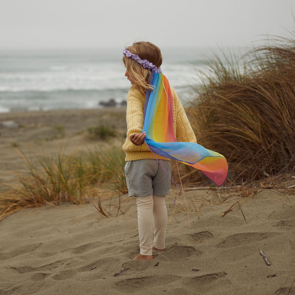 Sarah's Silks rainbow veil-Child playing on the beach in silk rainbow veil-- Bella Luna Toys