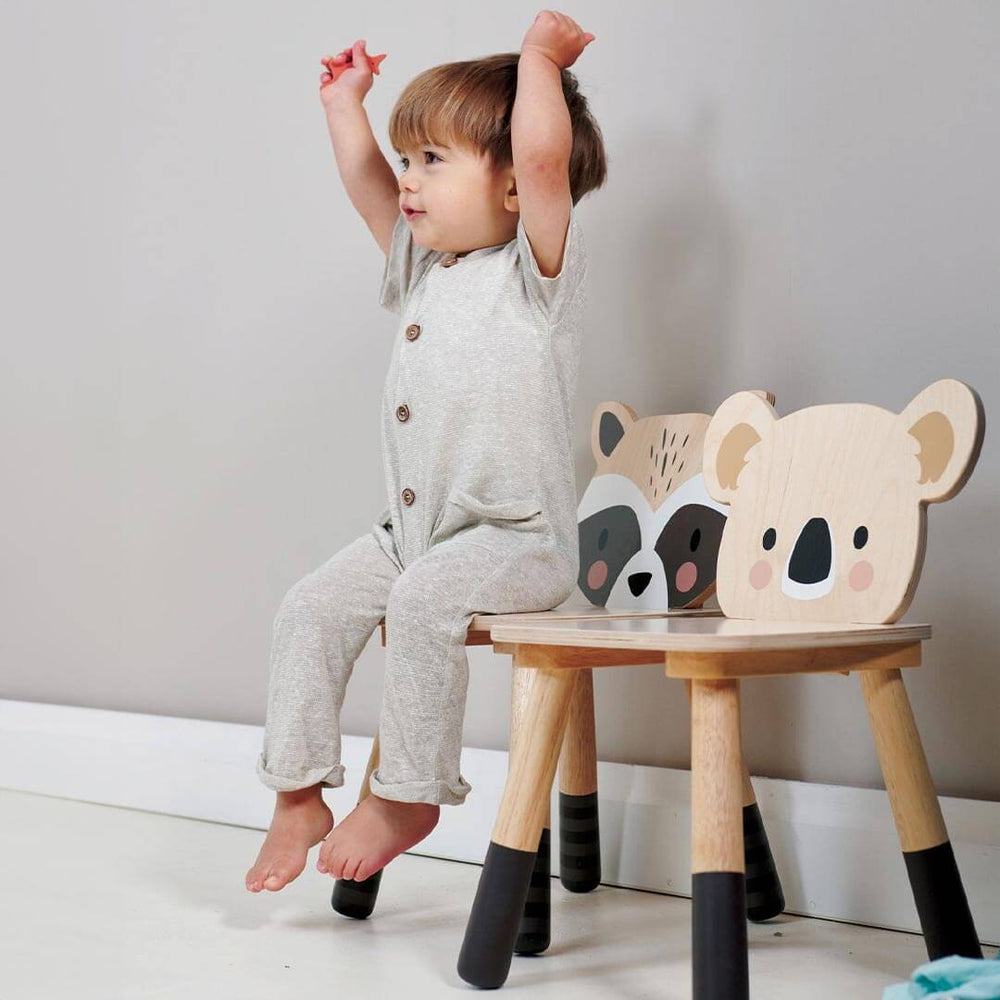 Child sitting on Tender Leaf Toys Wooden Raccoon Chair