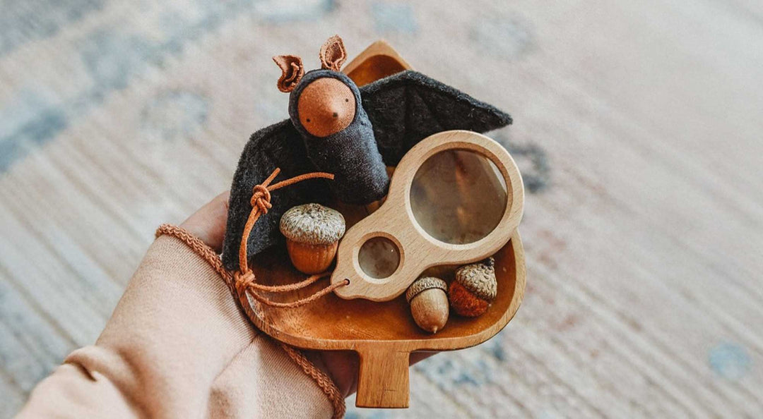 Someone is holding a wooden bowl with a felt bat.