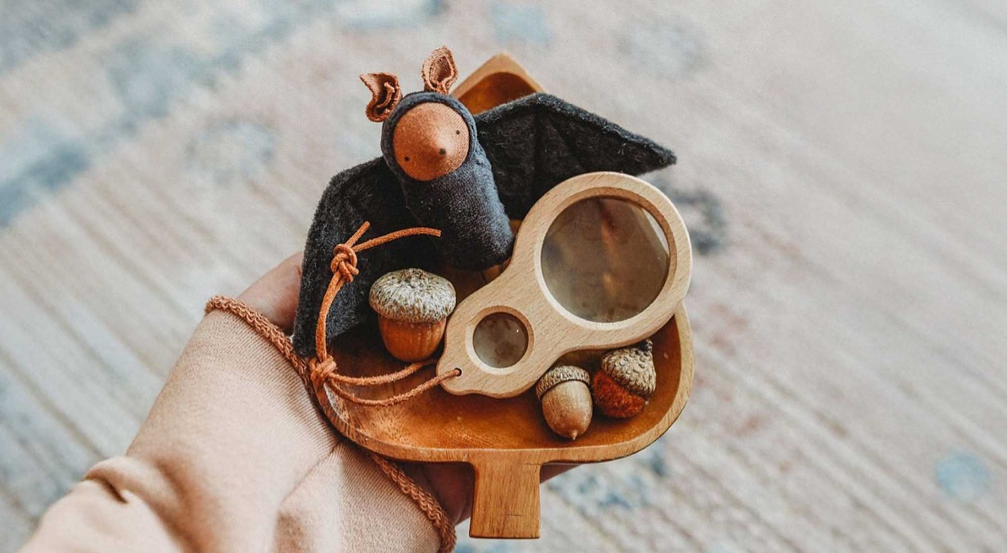 Someone is holding a wooden bowl with a felt bat.