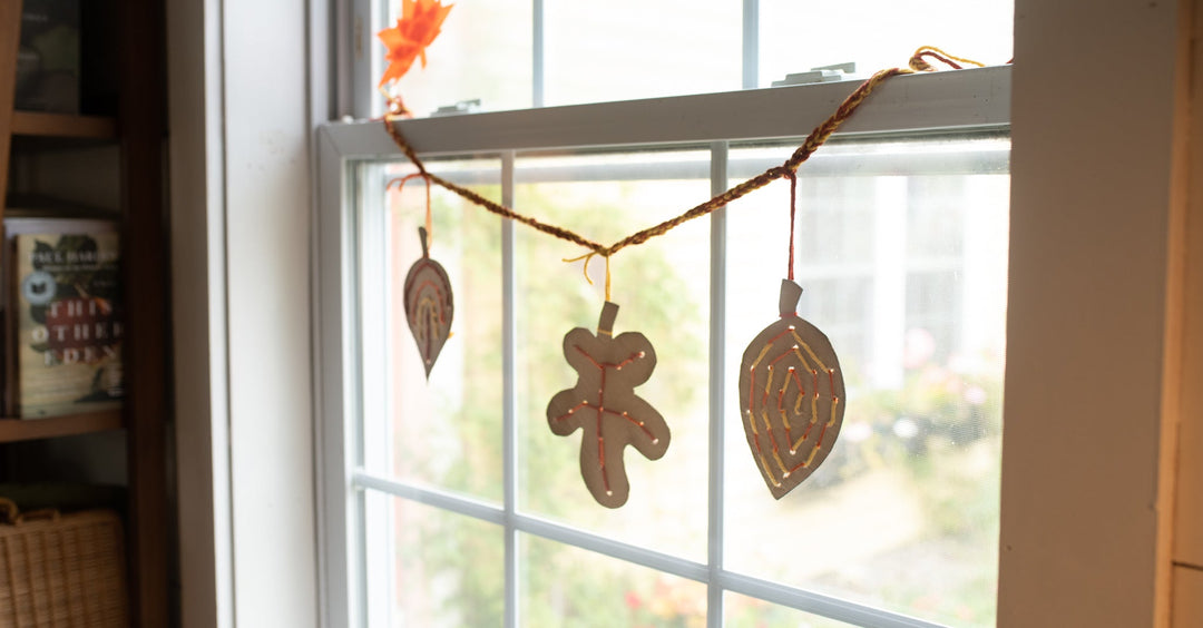 A lacing cards leaves projet turned into a garland hanging in a window.