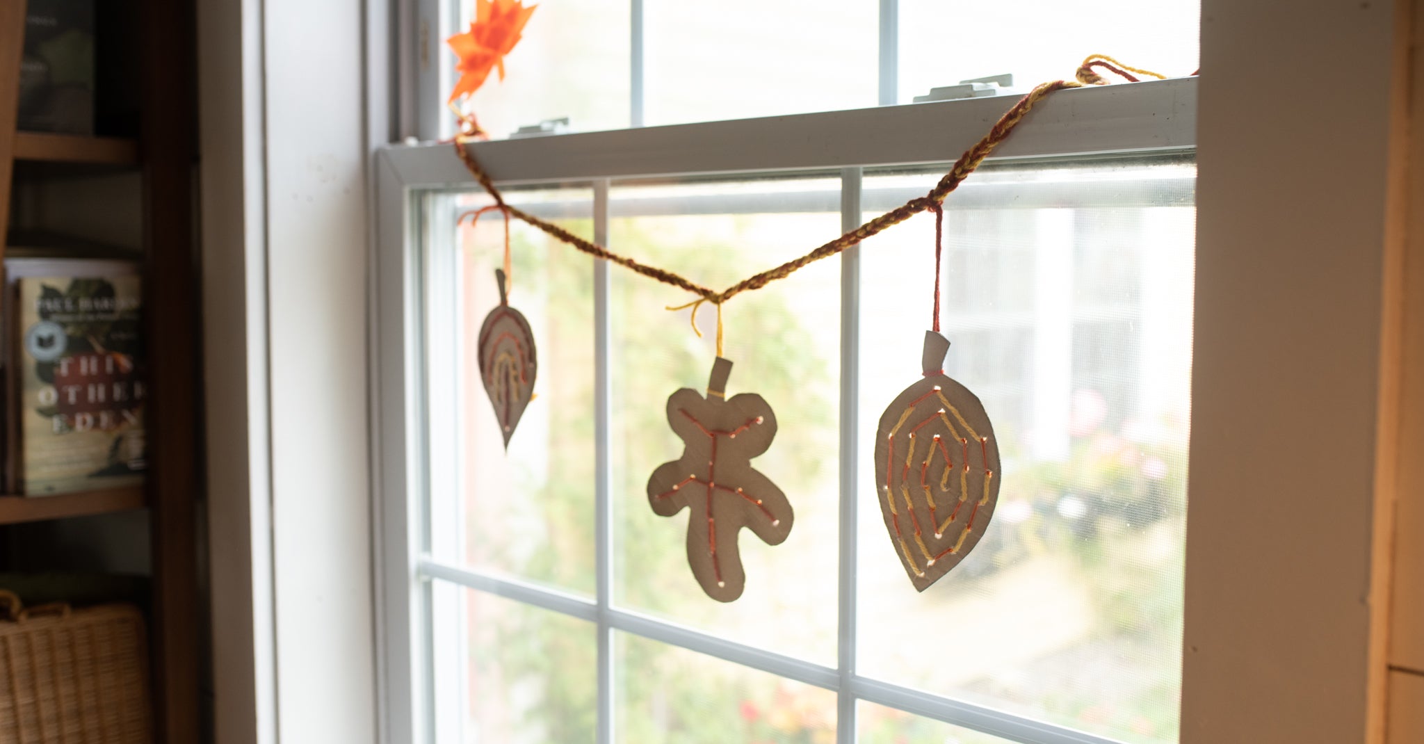 A lacing cards leaves projet turned into a garland hanging in a window.