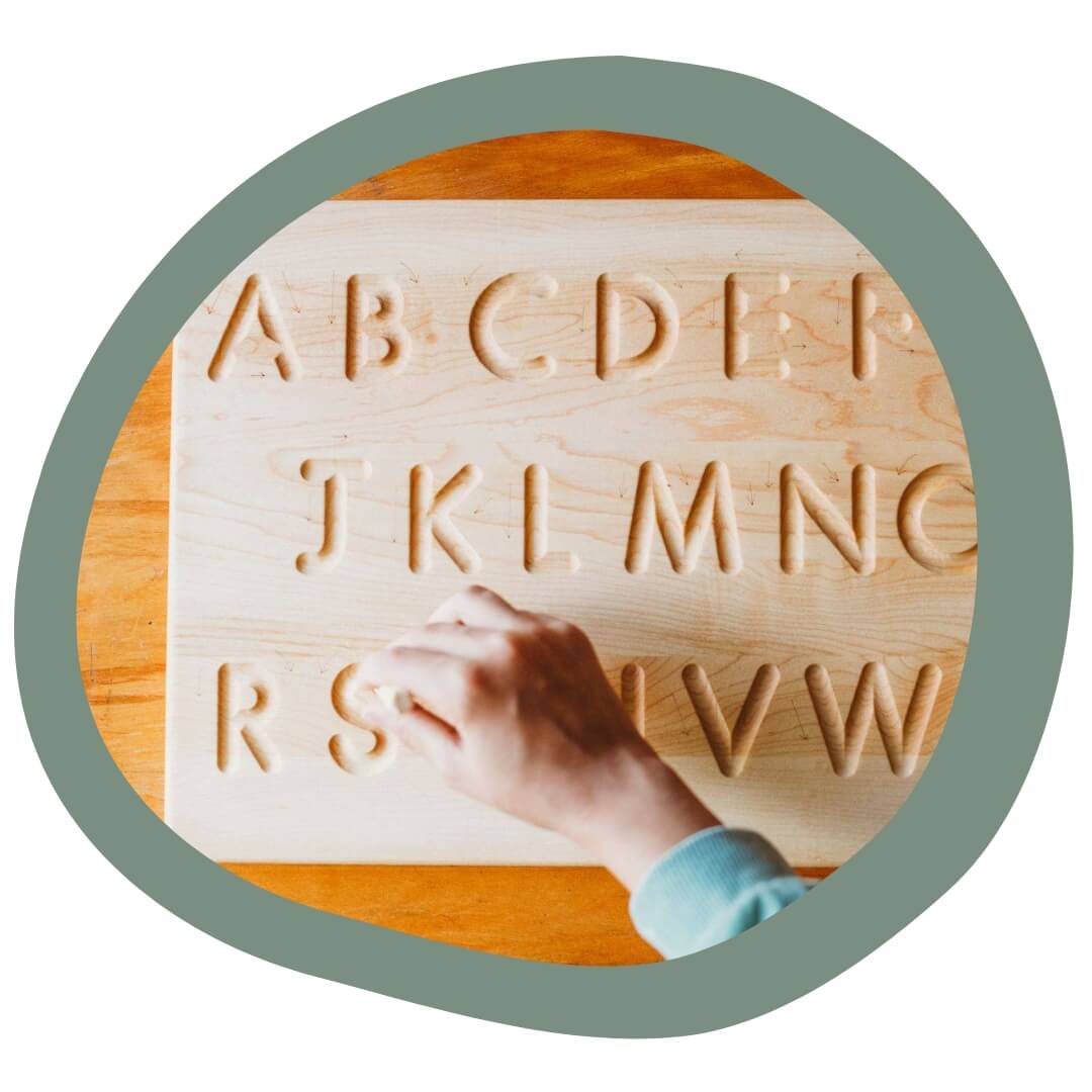 Mirus - child learning alphabet with wooden board