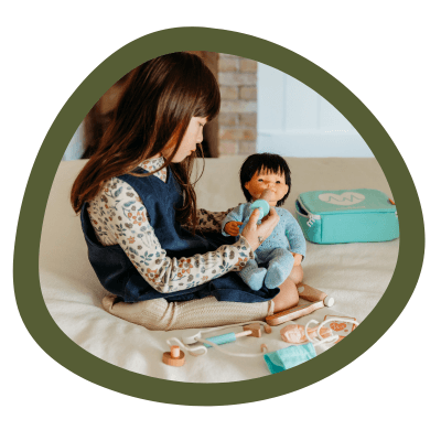 A child playing with a Miniland doll.