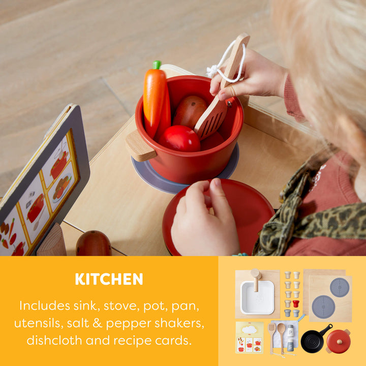 Child playing with toy kitchen set on a wooden surface