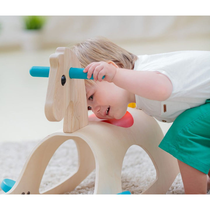 Child looking at PlanToys - Wooden Palomino Rocking Horse - Bella Luna Toys