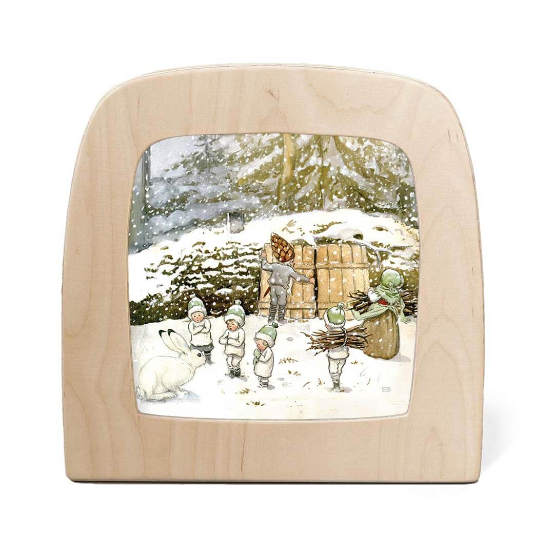 Wooden light with a winter scene of children and a bunny in the snow.