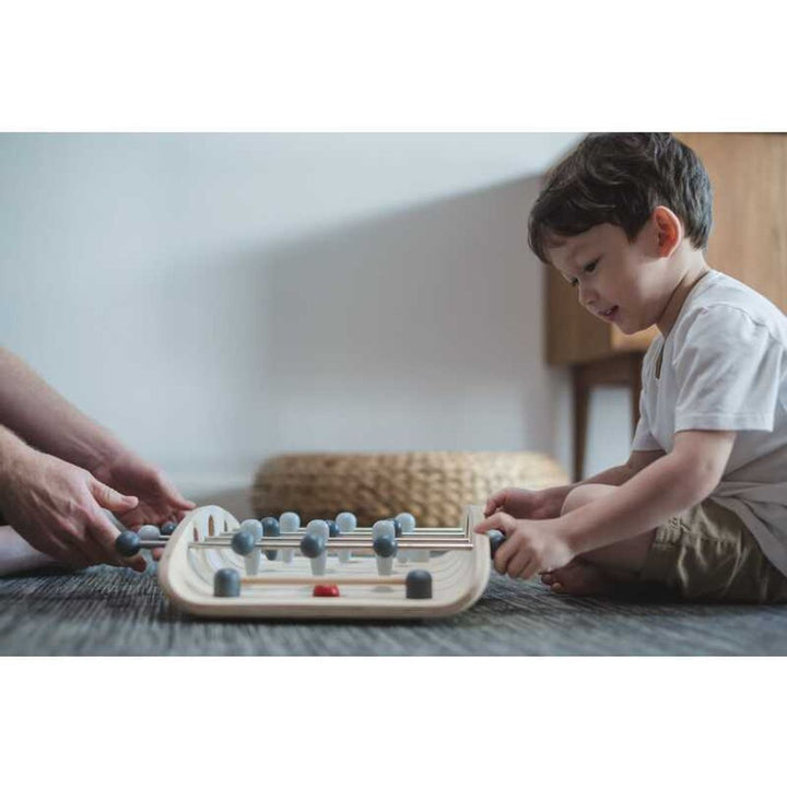 Child playing with PlanToys - Wooden Tabletop Soccer Game