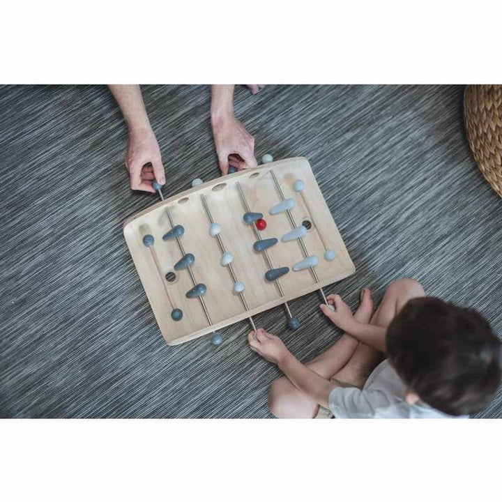 Father and son overhead shot of PlanToys - Wooden Tabletop Soccer Game