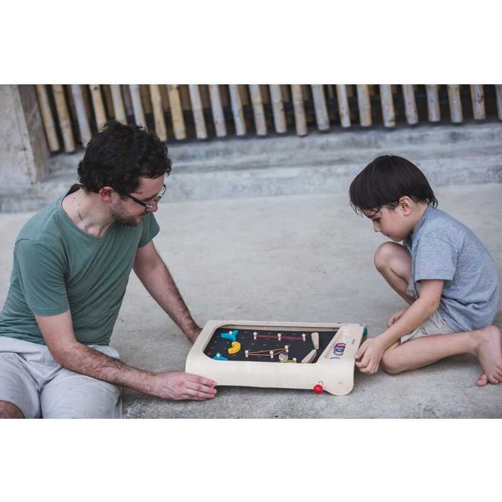 Father and son playing PlanToys - Wooden Pinball Game Set