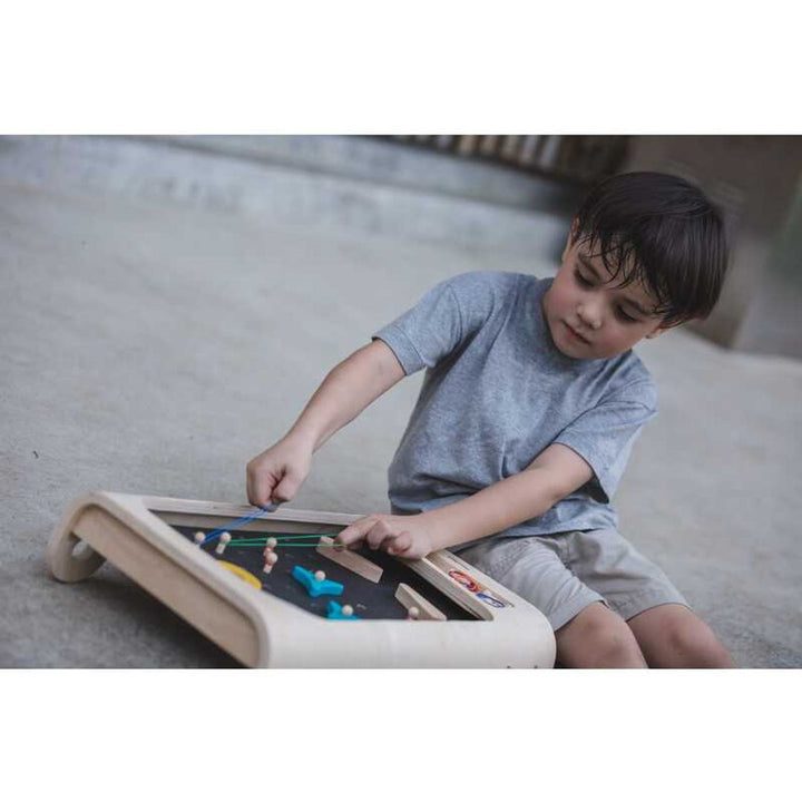 Child playing with PlanToys - Wooden Pinball Game Set