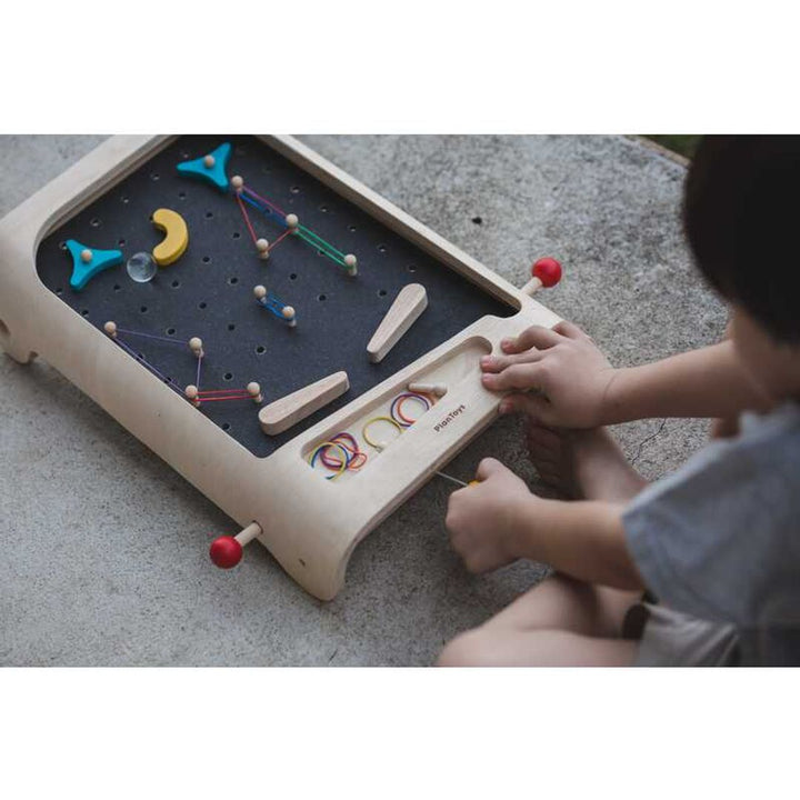 Child guiding ball down PlanToys - Wooden Pinball Game Set