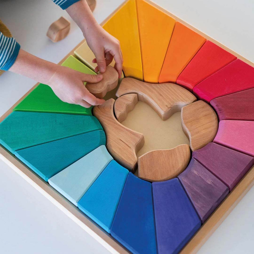 Children's hands interacting with a wooden puzzle toy featuring colorful interlocking pieces.