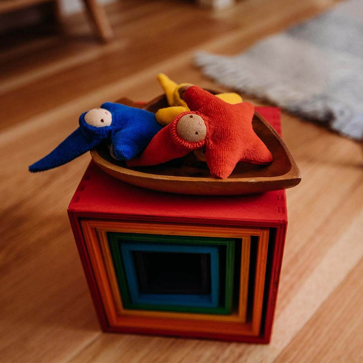 Colorful wooden blocks with soft toys on a wooden floor.