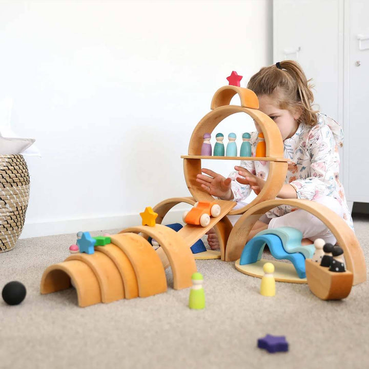 Child playing with a wooden toy set on a carpeted floor.