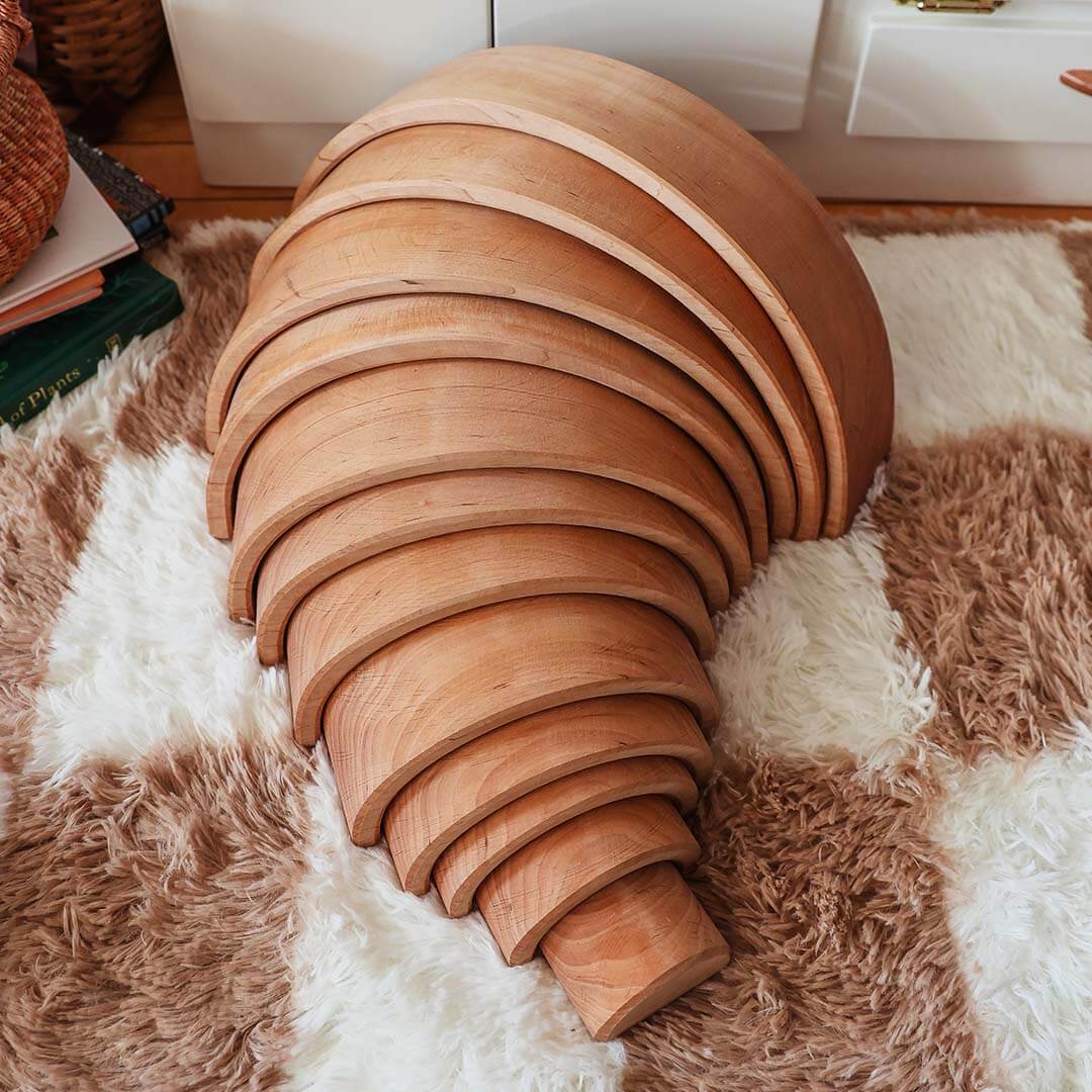 Wooden rainbow on a textured rug.