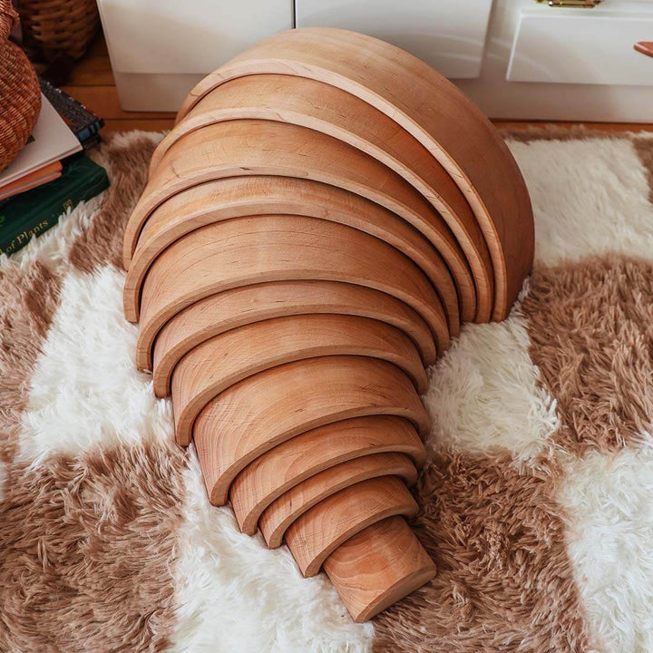 Wooden rainbow on a textured rug.