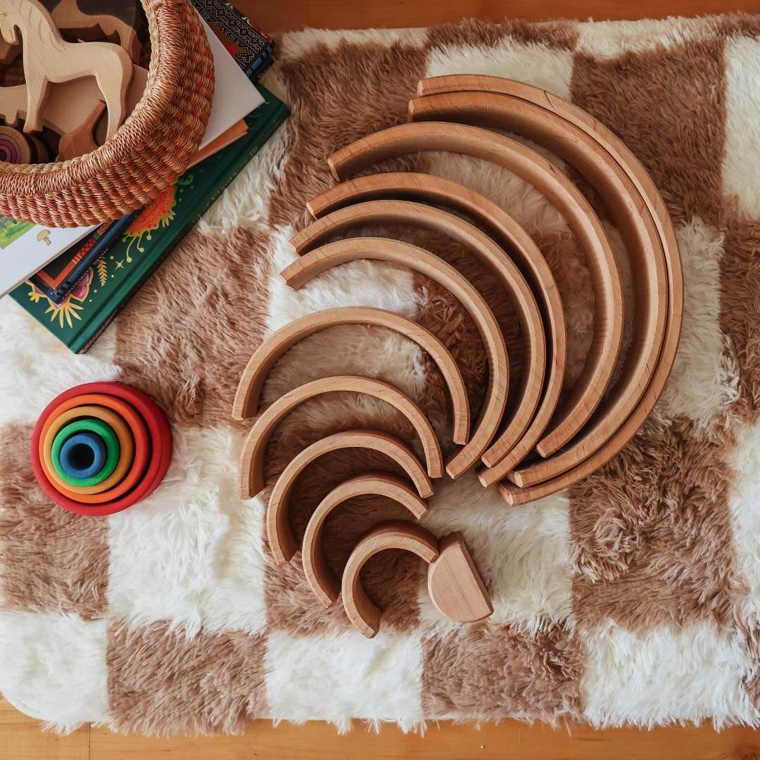 Set of wooden toys on a checkered fabric surface.