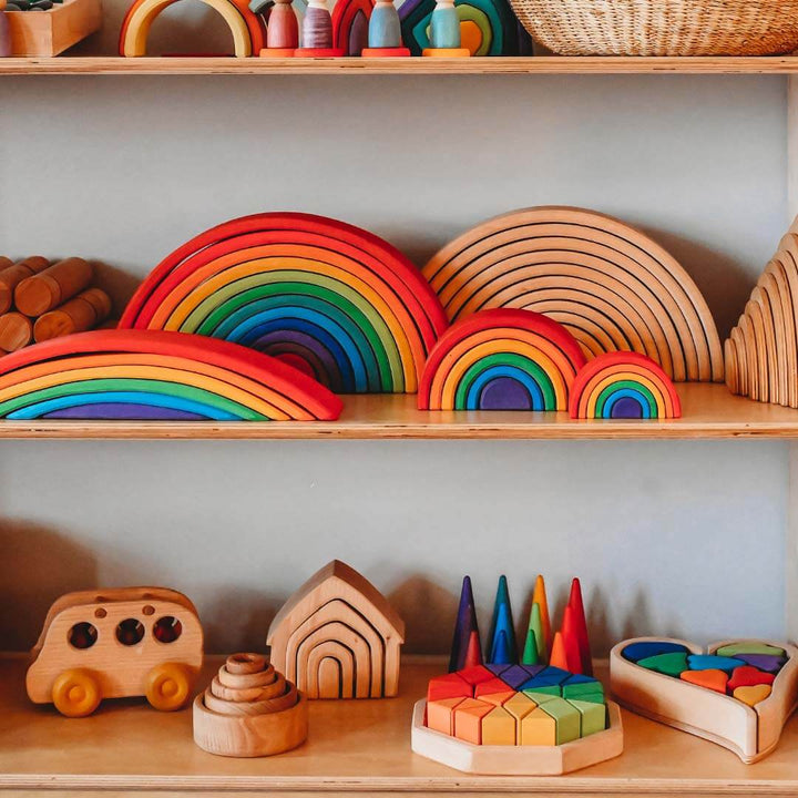 Wooden toys including rainbow shapes and geometric blocks on a shelf.