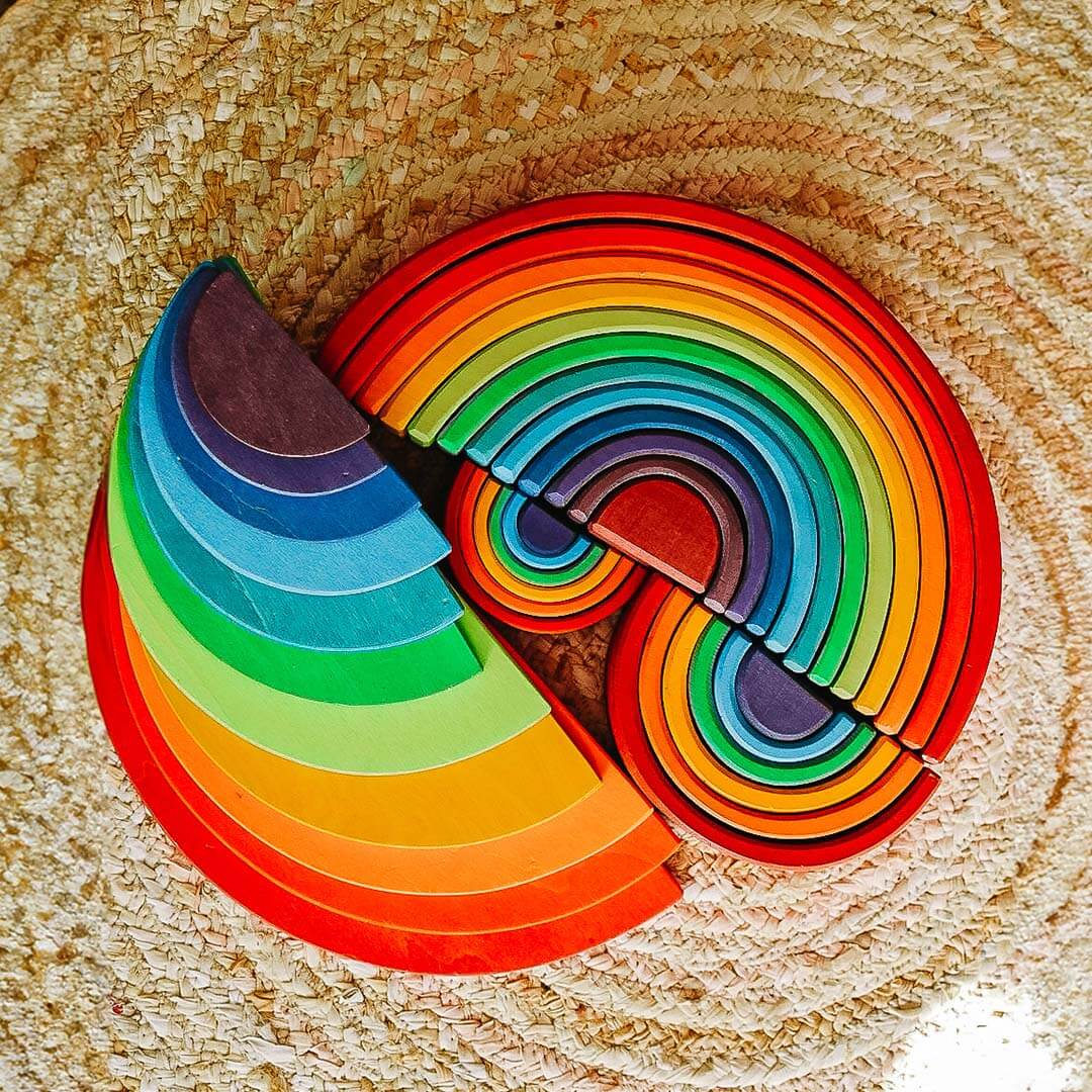 Colorful rainbow-shaped wooden toy on a wooden surface