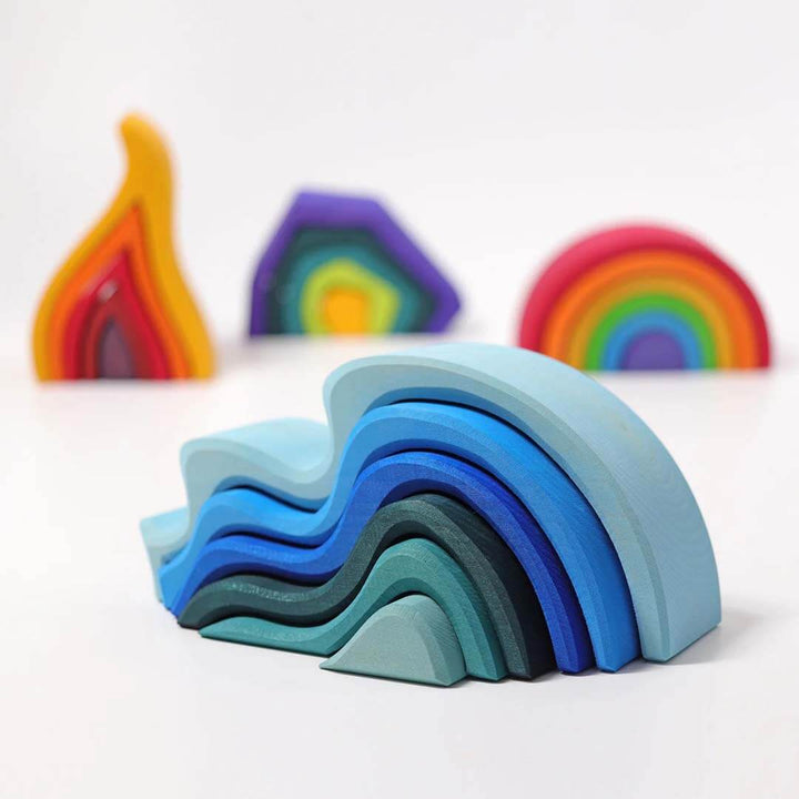 Blue wave shaped blocks and rainbow on a white background.