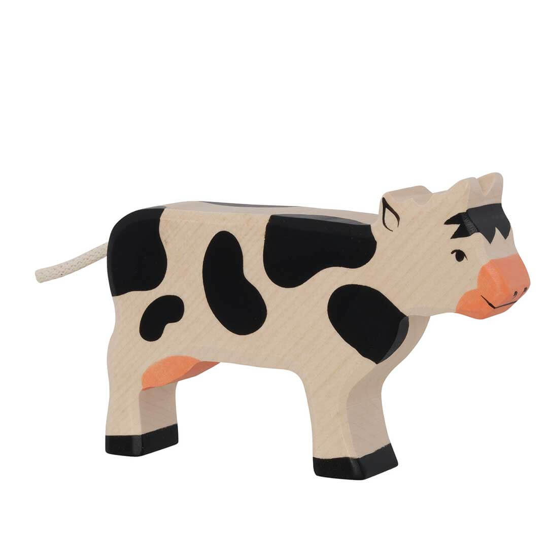 Handcrafted wooden toy cow with black and beige spots, orange nose and hooves, and a white tail, shown on a plain white background - Bella Luna Toys