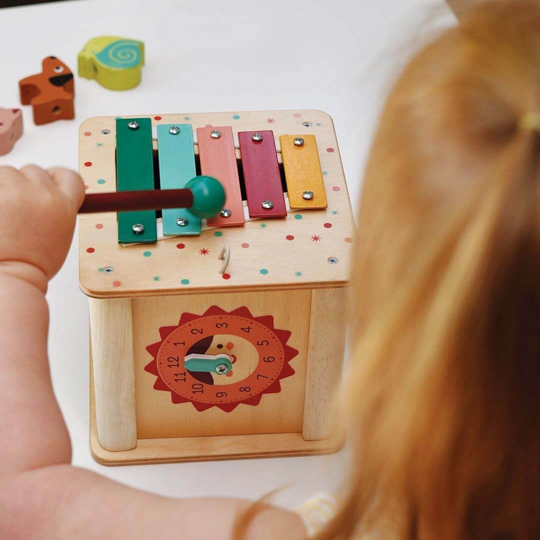 Child playing with a colorful wooden toy on a table.