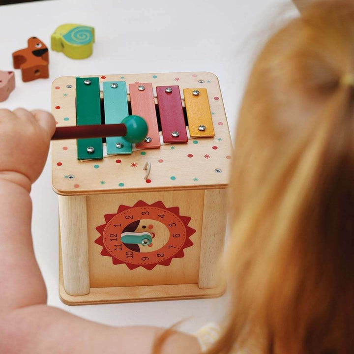 Child playing with a colorful wooden toy on a table.
