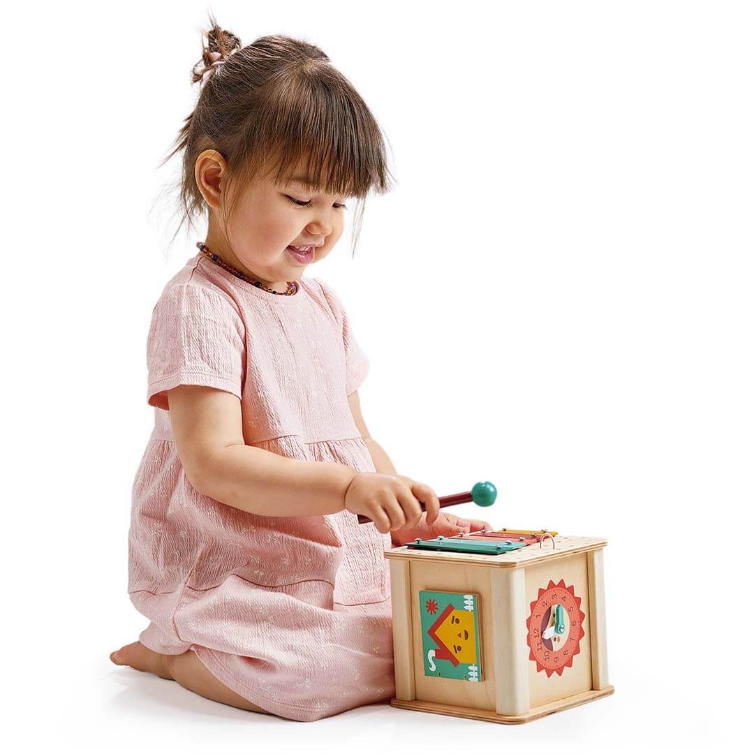 Child playing with a wooden toy box on a white background