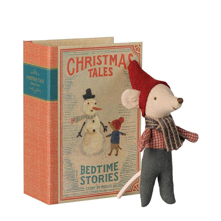 A vintage-style children's book titled "Christmas Tales: Bedtime Stories" with a small plush mouse doll standing beside it. The book has a coral-orange textured cover with a teal spine band and illustrated cover art showing a snowman and a child.