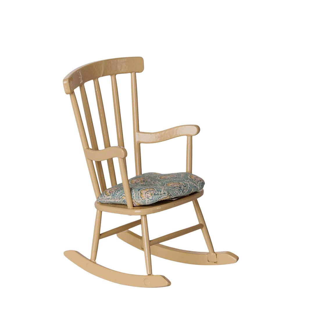 A light natural wood rocking chair with a curved spindle-back design and a patterned blue and beige cushion on the seat, isolated on a white background.