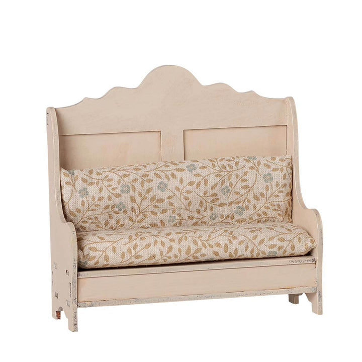 A vintage-style wooden bench with a distressed cream-painted frame and a floral patterned cushion set, shown against a plain white background.
