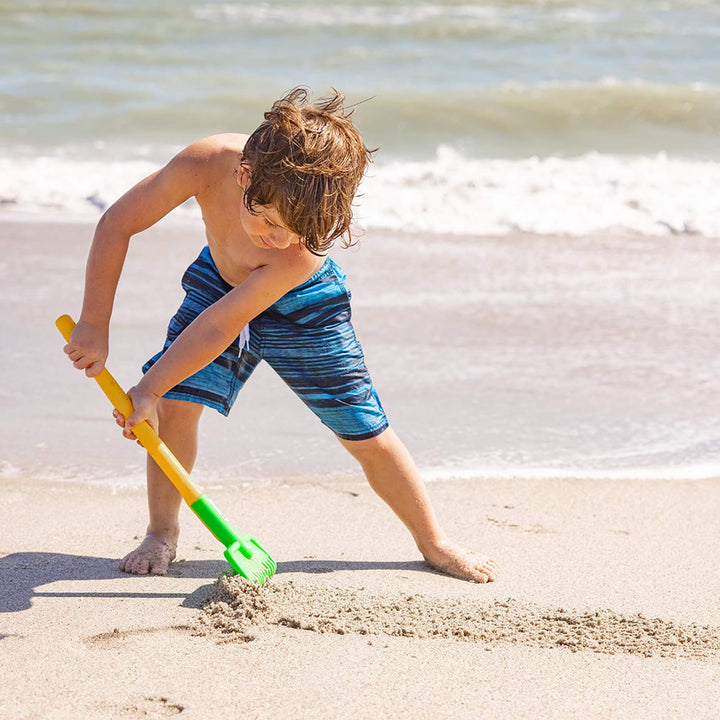 Child raking the sand on the beach with Spielstabil Long Handled Garden Rake