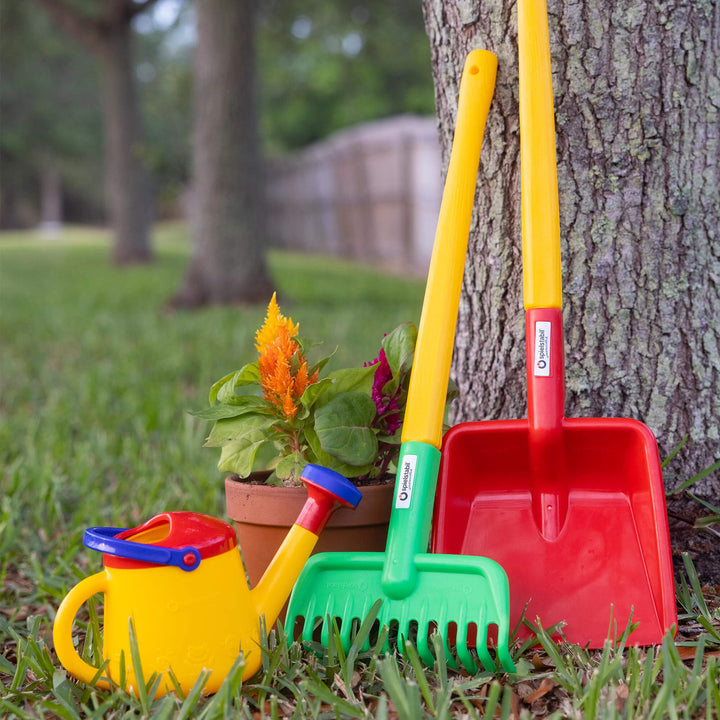 Spielstabil Long Handled Flat Shovel and Garden Rake leaning against a tree with a flower pot and Watering Can