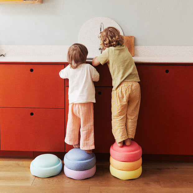 Children using Stapelstein stepping stones as a step stool to reach the counter top sink.