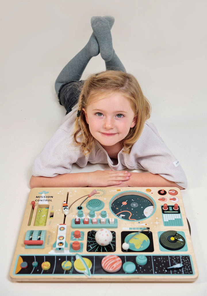 Girl laying behind Tender Leaf Toys - Wooden Space Station